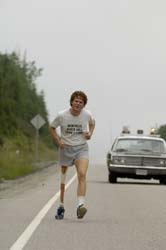 Photo of Terry Fox running next to a road.